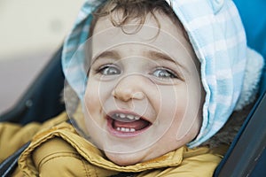 Close up portrait baby boy with big green eyes smiling