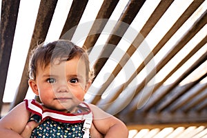 Close up portrait of a baby girl held in its mother`s arms