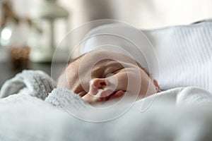 A close-up portrait of a baby girl who sleeps in a cradle or crib. Three-month-old girl sleeps sweetly