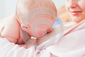 Close up portrait of baby nursing skin to skin