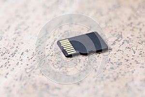 A close up portrait of the back of a black micro SD card, the connectors of the small piece of storage electronics hardware is