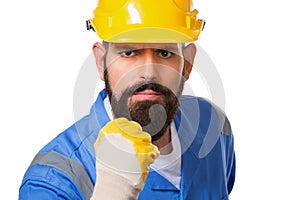 Close up portrait of bearded angry man builder in yellow helmet and blue uniform threatening with fist over white background