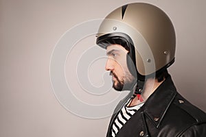 Close-up portrait of bearded biker man in leather jacket and motorcycle helmet.
