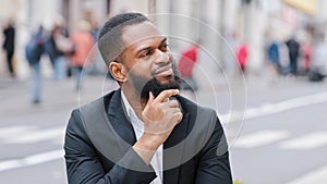 Close up portrait bearded ethnic man outdoors African American businessman looking away thinking about future think