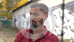 Close up portrait of bearded man posing confidently and looking at inquiringly photo