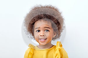 Close-up Portrait of beautiful african american child with fluffy curly hair looking at camera