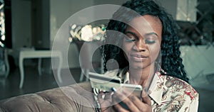 Close up portrait of a beautiful African American female with curly hair entering her credit card details on her