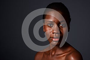 Close up beautiful african woman looking at camera with naked shoulders photo