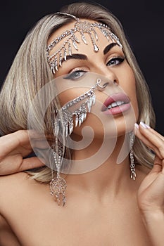 Close-up Portrait of a beautiful blonde girl. Jewelry accessories on the face of model. Beauty and style concept.