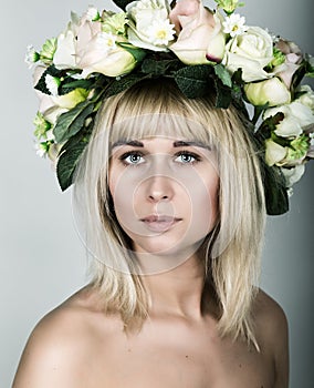 Close-up portrait beautiful blonde girl with red lips, bare shoulders, and a wreath on his head