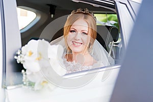 Close-up portrait of a beautiful bride in a wedding car window. The concept of wedding happiness.