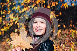 Close-up portrait of beautiful brunette girl on autumn background