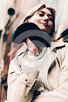 Close-up portrait Beautiful elegant woman wearing beige coat and black hat. Trendy casual outfit. Soft selective focus. grain