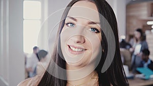 Close-up portrait of beautiful European female business woman with long straight hair, blue eyes in trendy office 4K.