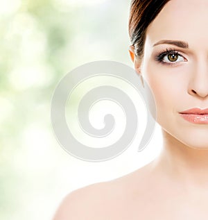 Close-up portrait of beautiful, fresh, healthy and sensual girl: over green background. Healthcare, spa, makeup and face lifting