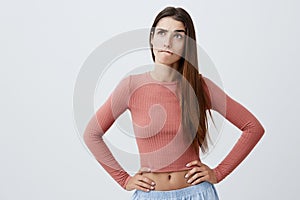 Close up portrait of beautiful funny young caucasian student girl with dark long hair in trendy clothes looking aside