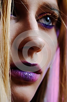 A close-up portrait of a beautiful girl of 20-25 years old with bright makeup and blue eyes.