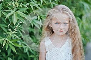 Close up portrait of beautiful little girl with blonde long hair and big blue eyes