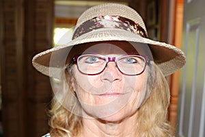Close up portrait of a beautiful older senior woman smiling with hat