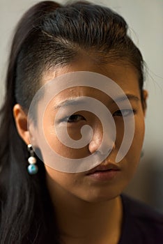 Close-up portrait of beautiful rebel Asian woman face outdoors
