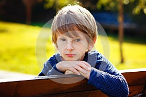 Close-up portrait of a beautiful red-haired boy with a very serious look. A sad expression on his face. Outdoor, copy space