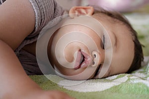 close-up portrait of a beautiful sleeping baby on bed. New family and baby protection from mom concept