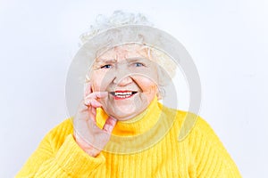 Close up portrait of beautiful smiling senior woman wear yellow sweater