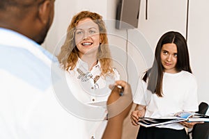 Close-up portrait of a beautiful smiling student on bright background. Happy ginger female teacher smiling to her