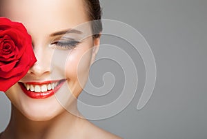 Close-up portrait of beautiful smiling woman with red rose.