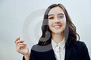 close up portrait of a beautiful smiling young businesswoman wearing black jacket on a white background looking at