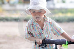 close up portrait of beautiful sweet boy, wearing White bucket hat and colorful shirt, looking at camera, big dark eyes