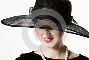 Close-up portrait of a beautiful woman in a black hat in retro s