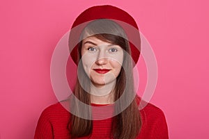 Close up portrait of beautiful woman with bright pomade, charming lady wearing red clothes and beret posing over pink backgound in