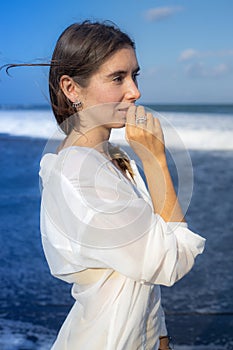 Close up portrait of beautiful woman with jewelry. Caucasian woman enjoying sunlight and looking to the ocean. Beauty and fashion