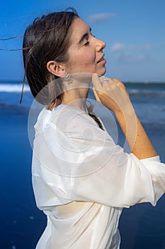 Close up portrait of beautiful woman with jewelry. Closed eyes. Caucasian woman enjoying sunlight. Beauty and fashion concept