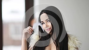 Close up portrait of beautiful woman play with feather near her face