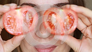 Close up portrait of beautiful woman with tomato on eyes stop motion loop. Concept of raw food, healthy vitamins