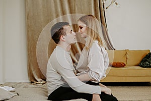 Close-up portrait of a beautiful young couple hugs in bed at home