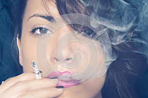 Close up portrait of beautiful young girl smoking cigarette with a lot of smoke