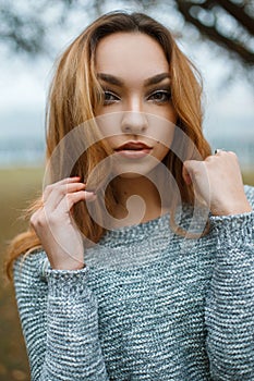 Close-up portrait of a beautiful young girl in stylish winter sw