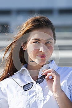 Close up portrait of beautiful young happy brunette woman with fresh skin, summer street outdoors