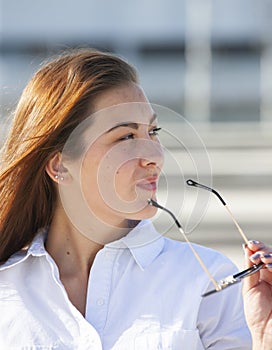 Close up portrait of beautiful young happy brunette woman with fresh skin, summer street outdoors