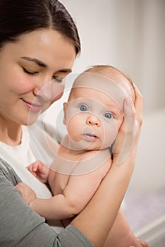 Close up portrait of beautiful young mother girl kissing her newborn baby