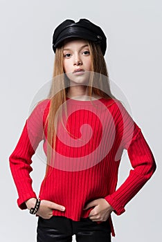 Close-up portrait of beautiful young redhead girl wearing red sweater posing in studio.