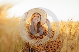 Close-up portrait of beautiful young woman in a countryside field. Female face in the rays of sunset. Freedome and