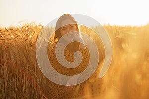 Close-up portrait of beautiful young woman in a countryside field. Female face in the rays of sunset. Freedome and