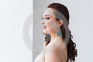 Close-up portrait of beautiful young woman with elegant hairstyle and luxurious jewelry and bijouterie.