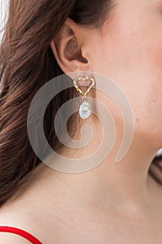 Close-up portrait of beautiful young woman with elegant hairstyle and luxurious jewelry and bijouterie.