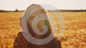 Close-up portrait of beautiful young woman in a field. Female face in the rays of sunset. Freedome and happiness concept