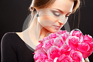 Close-up portrait of beautiful young woman with luxury jewelry and perfect make up holding bouquet